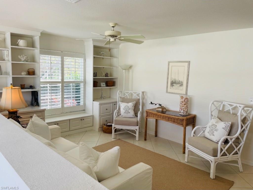 Living area with light tile patterned floors and a ceiling fan