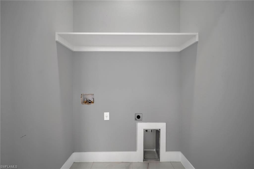 Laundry room with hookup for a washing machine, electric dryer hookup, and tile patterned flooring
