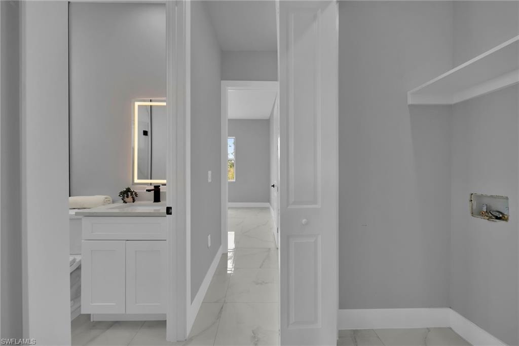 Bathroom with light marble finish floors and vanity