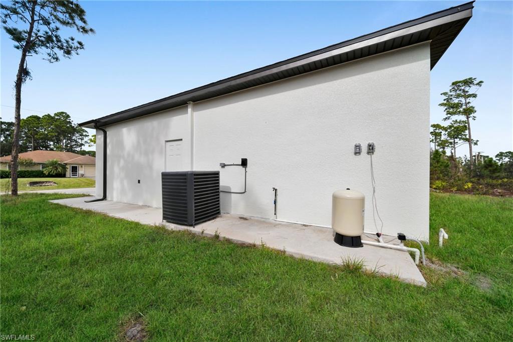 View of side of property featuring stucco siding and a yard