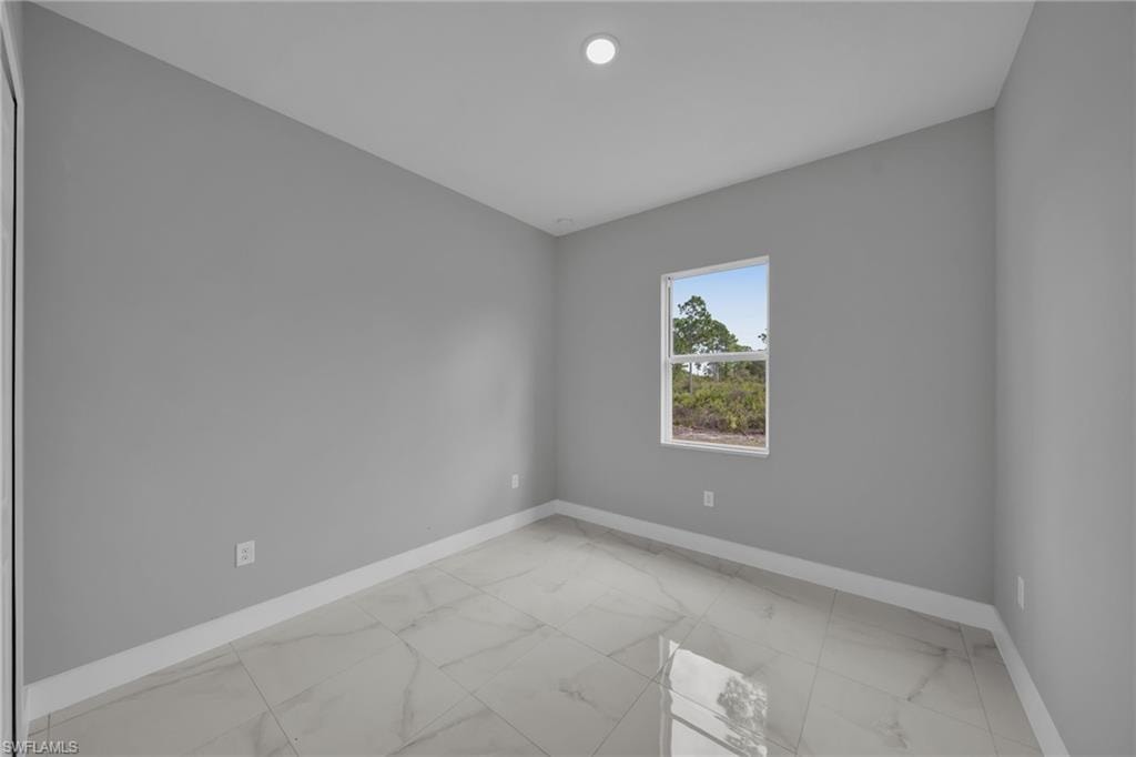 Empty room with light marble finish flooring and baseboards
