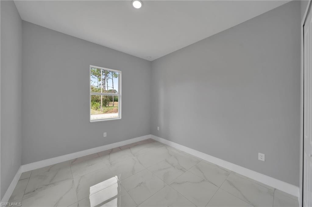 Spare room with light marble finish floors