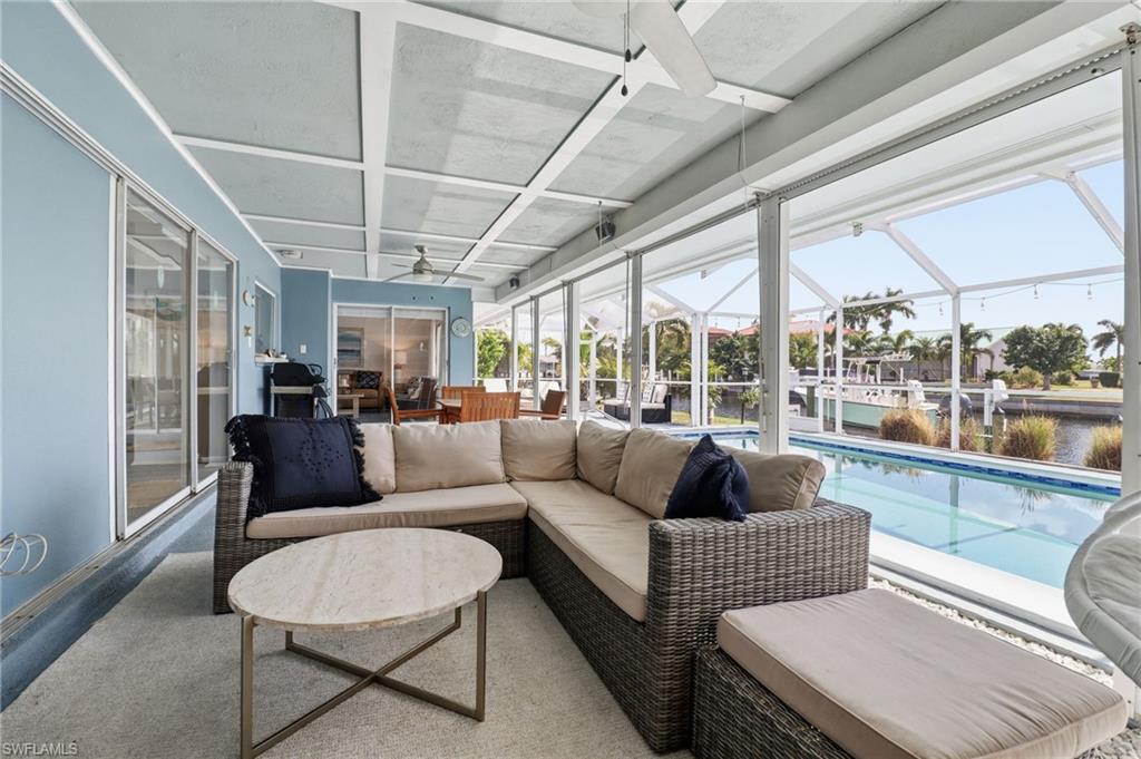 Sunroom with ceiling fan, an outdoor hangout area, a patio, and a water view
