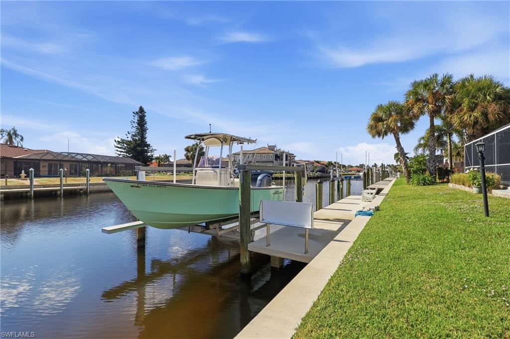Dock with a yard, boat lift, and a water view