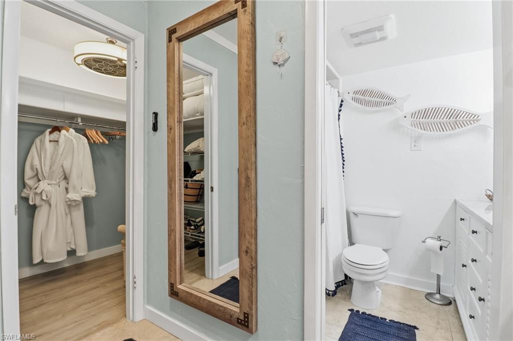 Bathroom featuring a spacious closet, vanity, and a shower with curtain