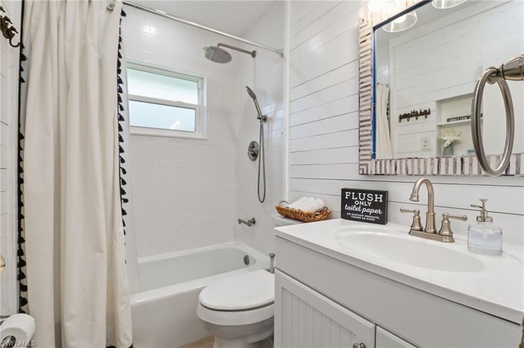 Bathroom featuring shower / bath combo with shower curtain and vanity