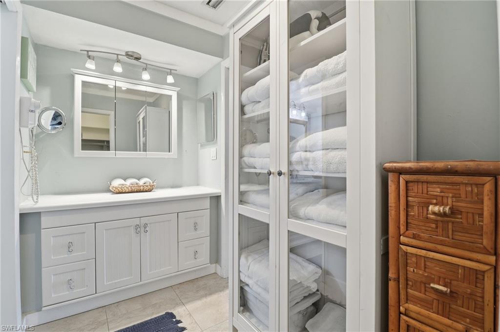 Bathroom featuring vanity, a closet, and light tile patterned flooring