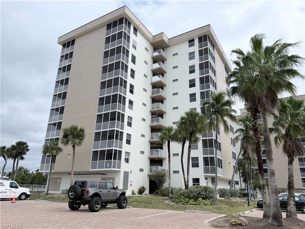 View of apartment building / complex with uncovered parking