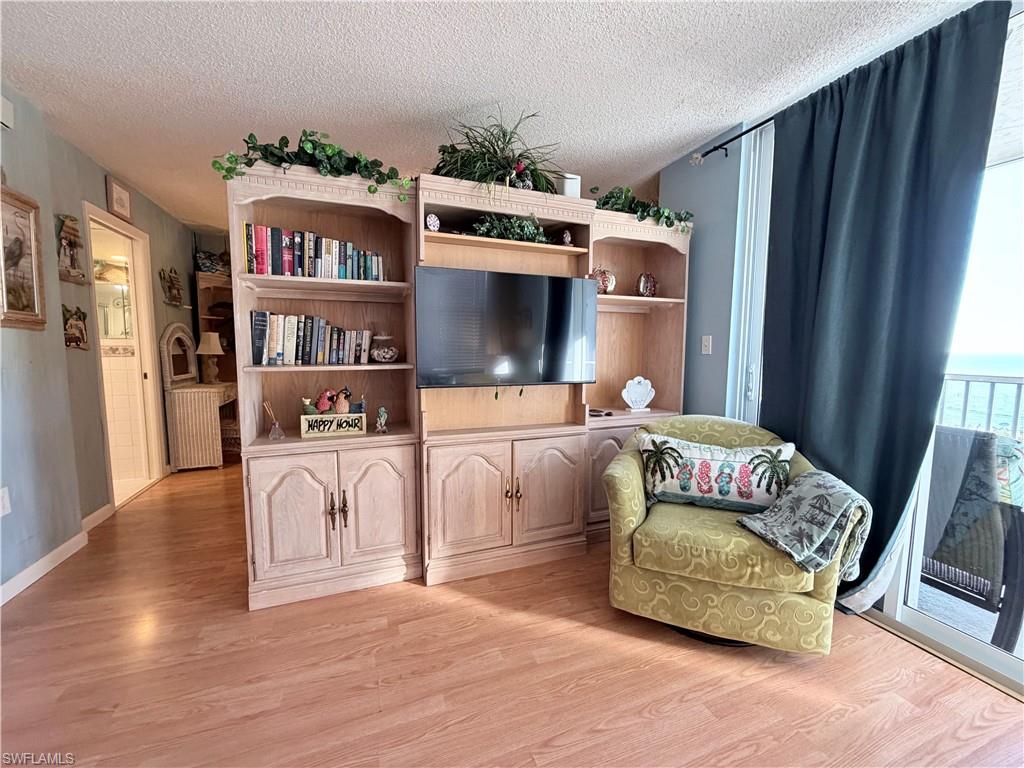 Sitting room with a textured ceiling and light wood-type flooring