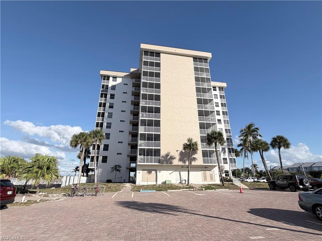 View of apartment building / complex featuring uncovered parking