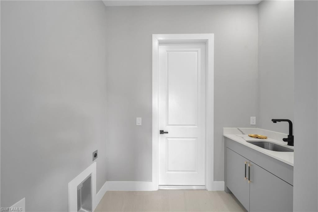 Washroom with electric dryer hookup and cabinet space