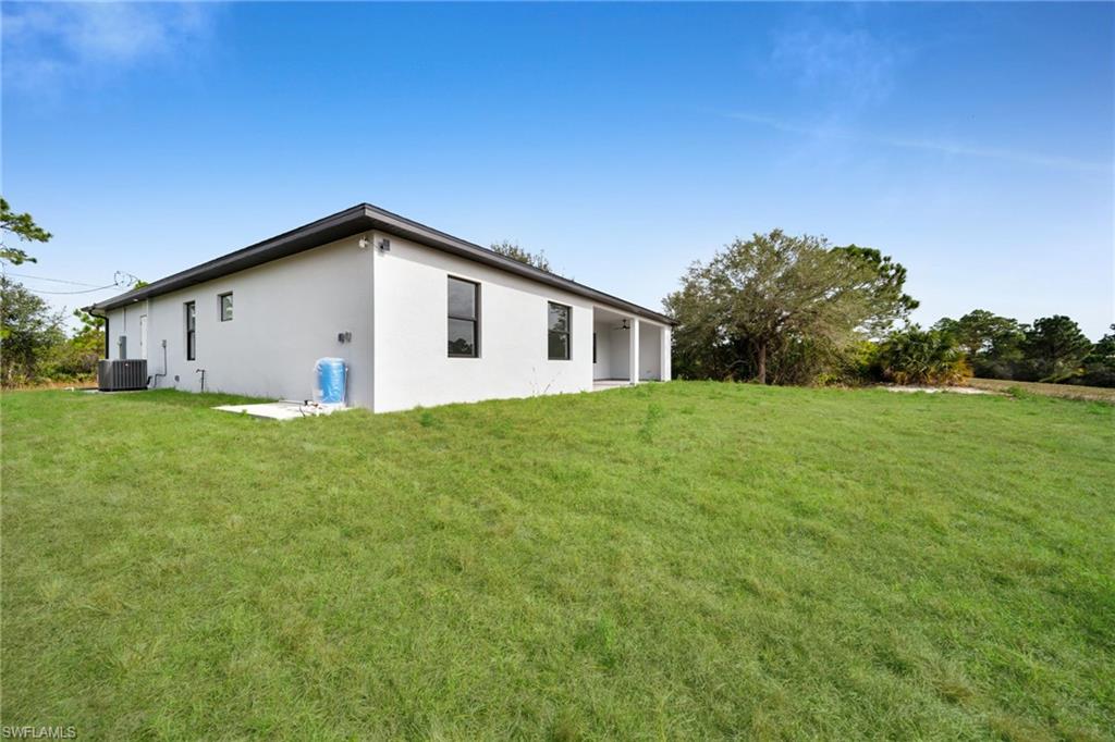 Back of house featuring a yard and stucco siding