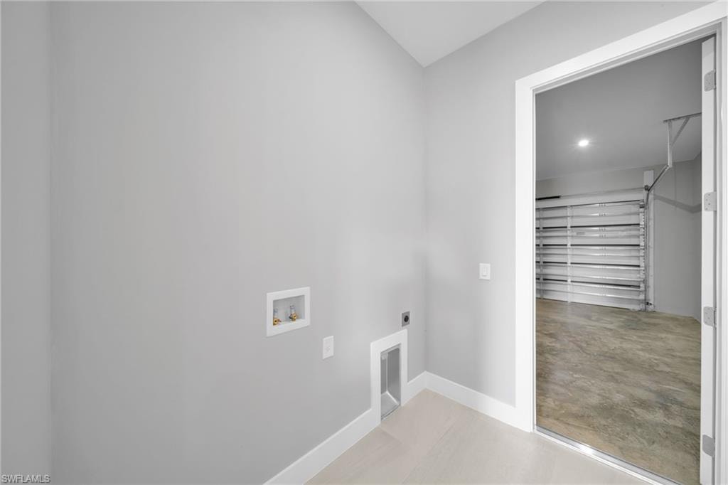 Washroom featuring electric dryer hookup, finished concrete flooring, and washer hookup