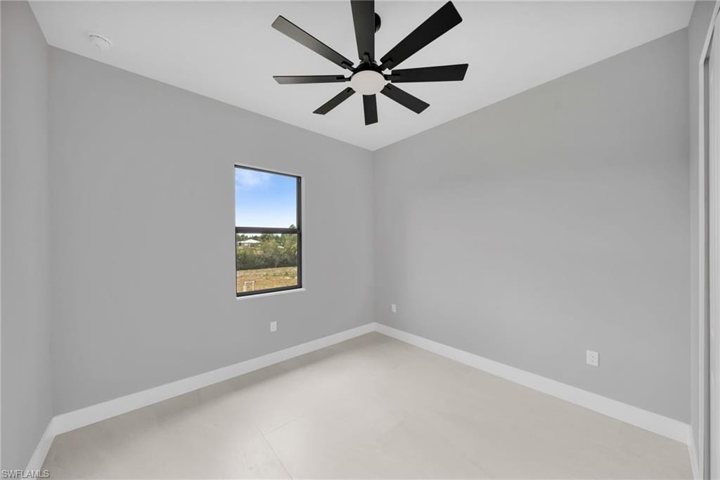 Unfurnished room featuring baseboards and a ceiling fan