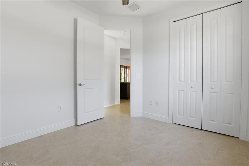 Unfurnished bedroom featuring baseboards and a closet