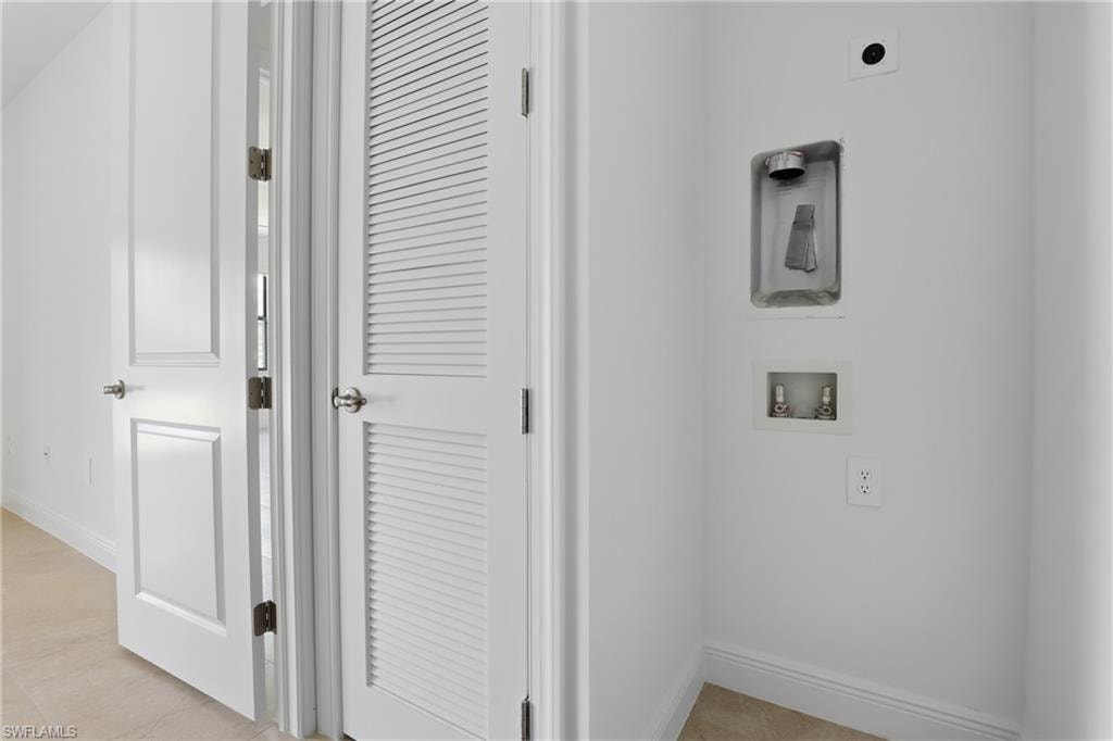 Laundry room featuring hookup for a washing machine and light tile patterned floors