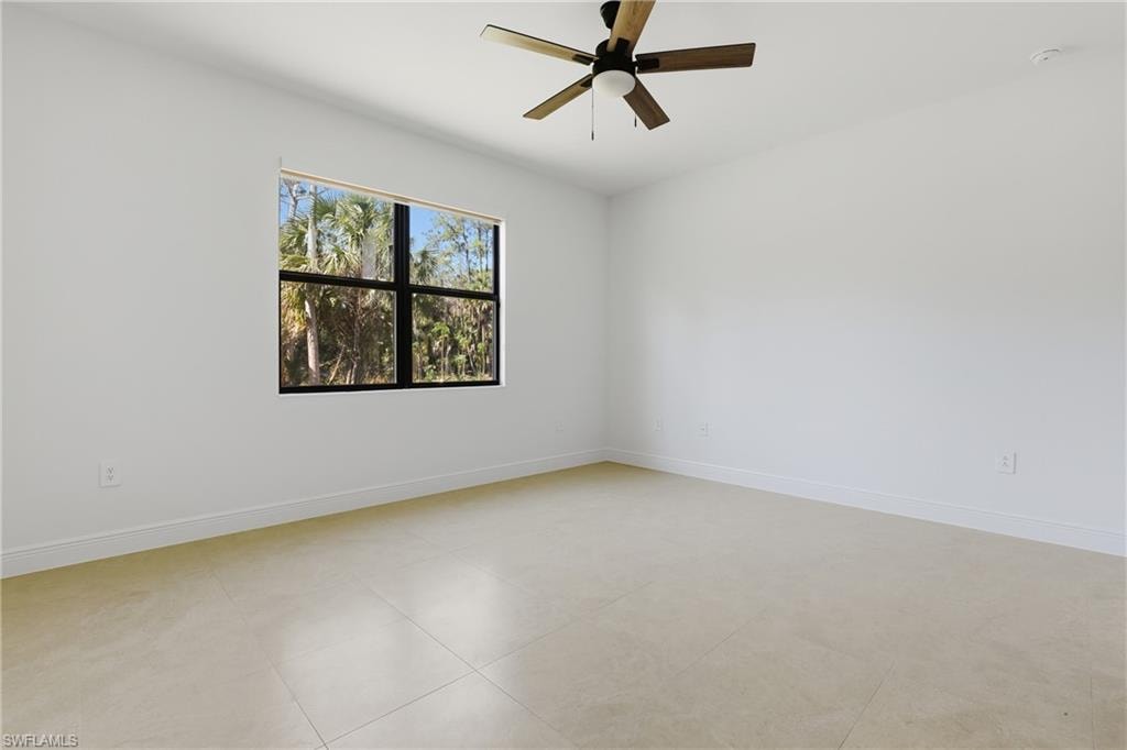 Unfurnished room featuring ceiling fan and baseboards