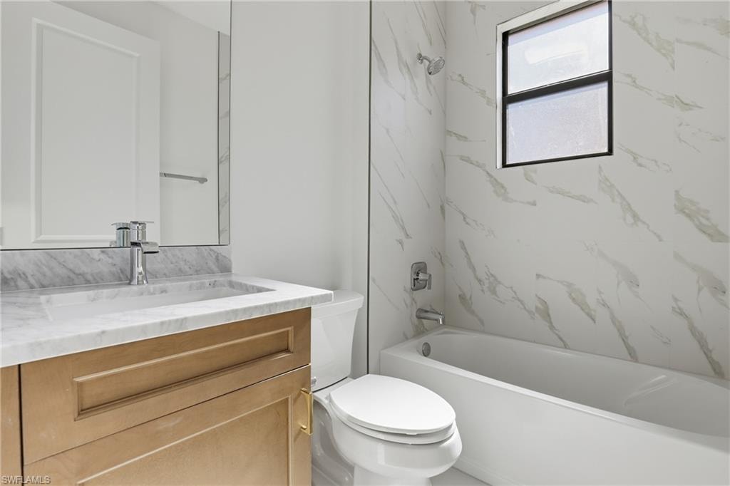 Full bath featuring vanity and washtub / shower combination