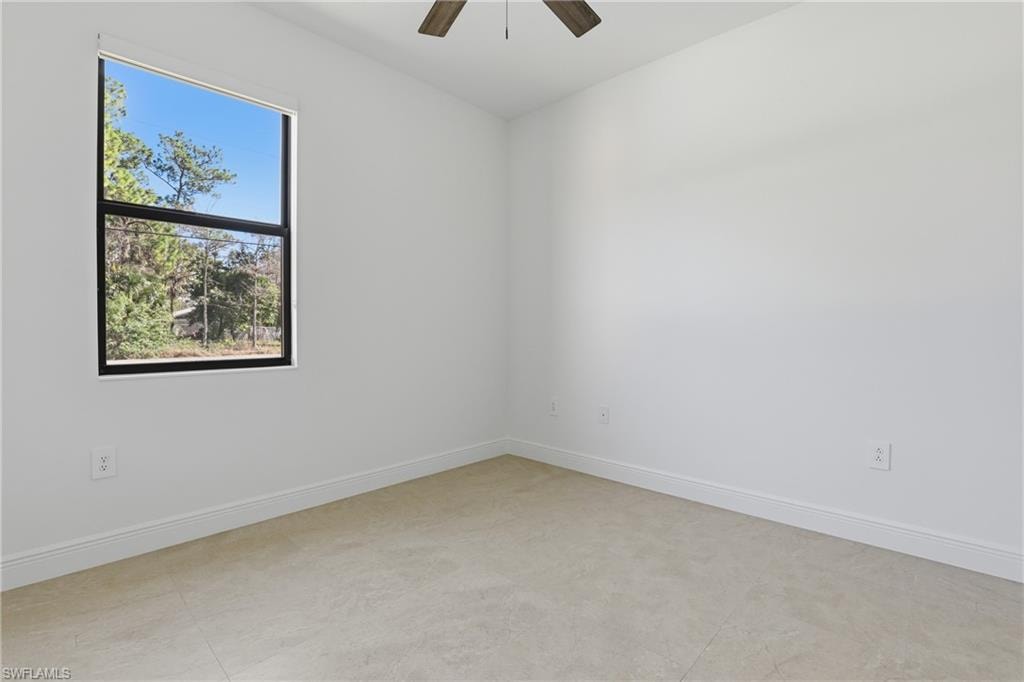 Spare room with baseboards and ceiling fan