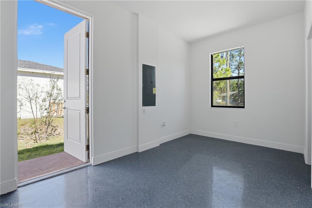 Empty room featuring electric panel and speckle patterned floor