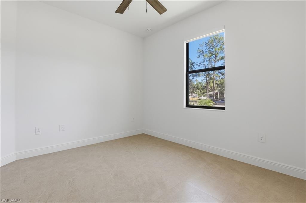 Unfurnished room featuring baseboards and ceiling fan