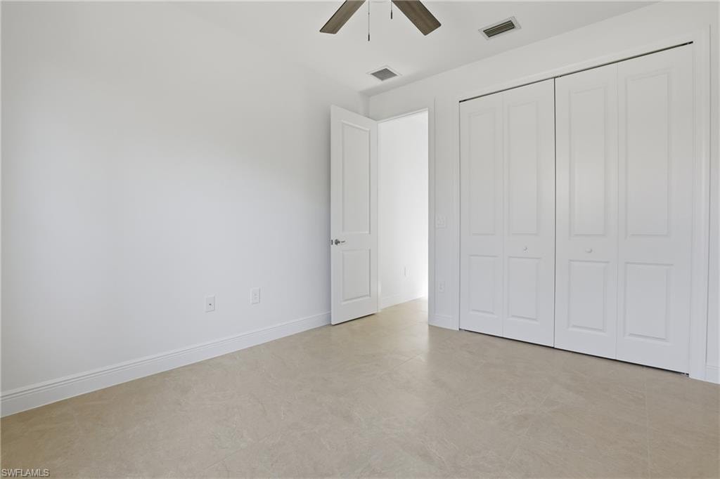 Unfurnished bedroom with a ceiling fan and a closet