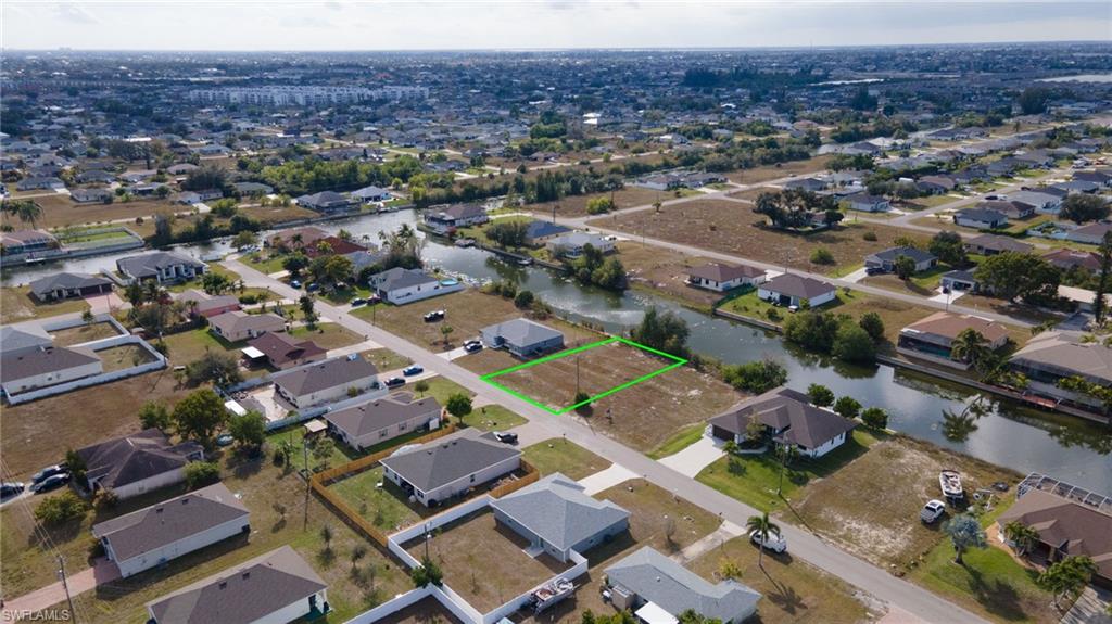 Aerial view of property and surrounding area featuring nearby suburban area and property parcel outlined