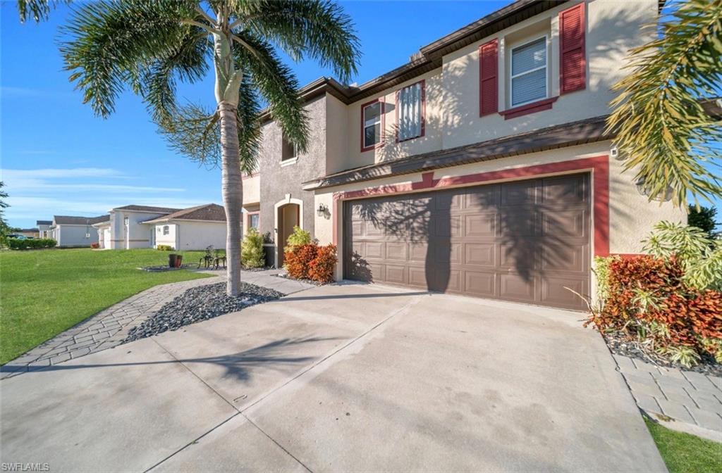 Mediterranean / spanish home with driveway, an attached garage, stucco siding, and a front yard