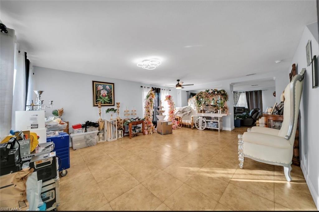 Living room with ceiling fan and light tile patterned floors