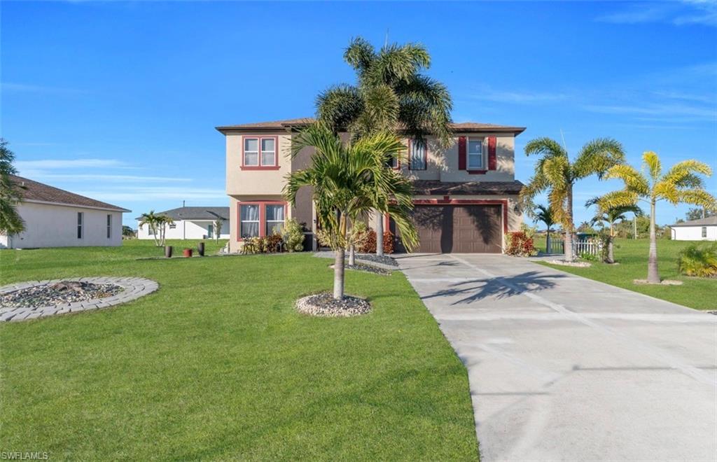 View of front of house featuring driveway, a front lawn, an attached garage, and stucco siding