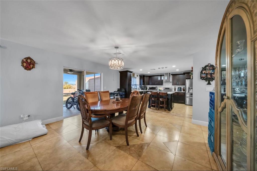 Dining area featuring a chandelier, light tile patterned flooring, recessed lighting, and a ceiling fan