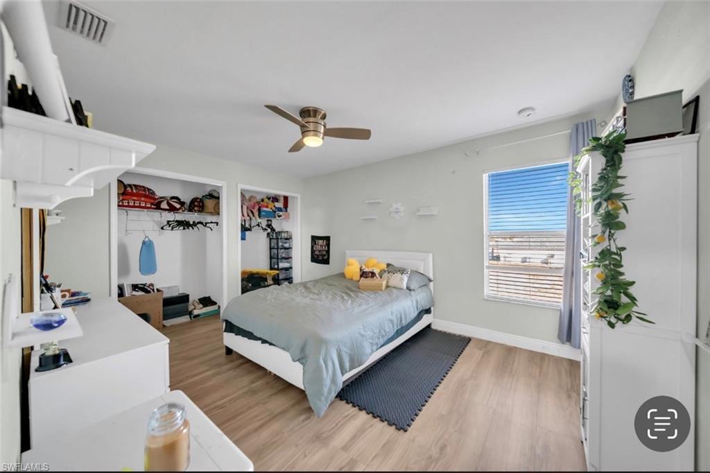 Bedroom featuring light wood finished floors, ceiling fan, and a closet