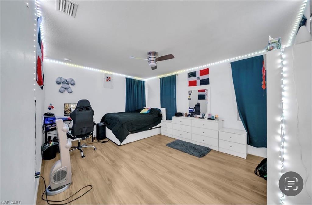 Bedroom with ceiling fan and light wood-type flooring