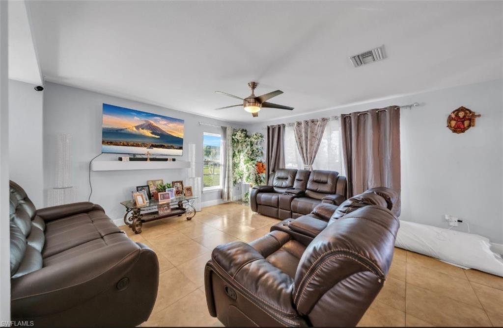 Living area with tile patterned floors and a ceiling fan