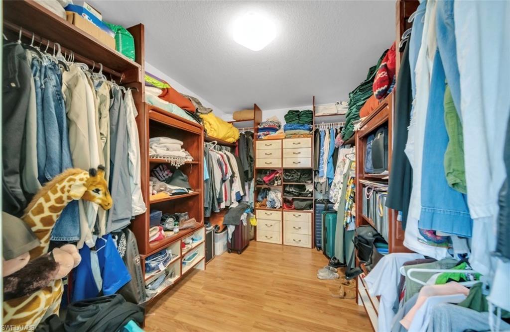 Walk in closet with light wood-type flooring