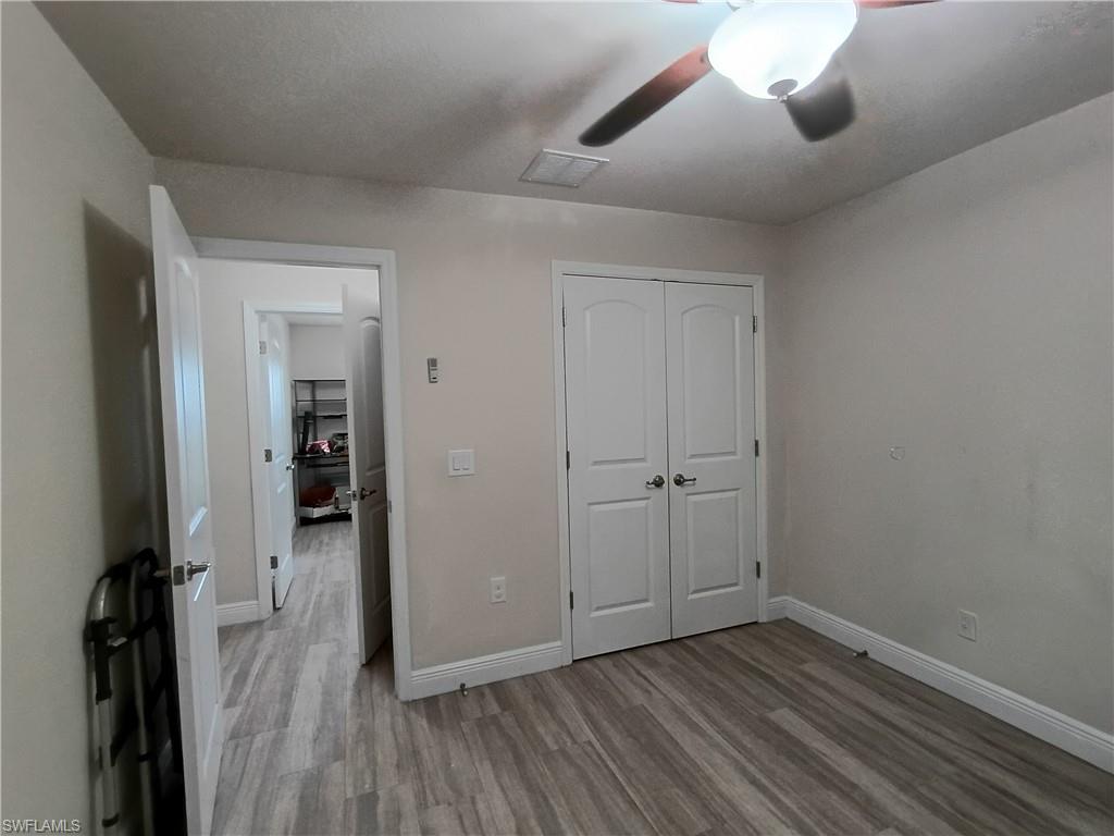Unfurnished bedroom featuring a closet, light wood-style flooring, and a ceiling fan