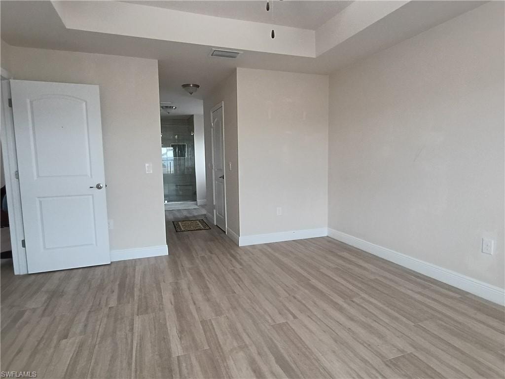 Empty room with baseboards and light wood-style flooring