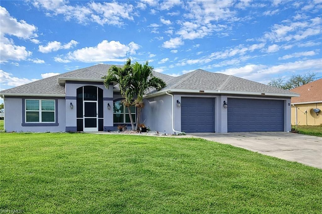 Ranch-style home with stucco siding, a front lawn, and driveway