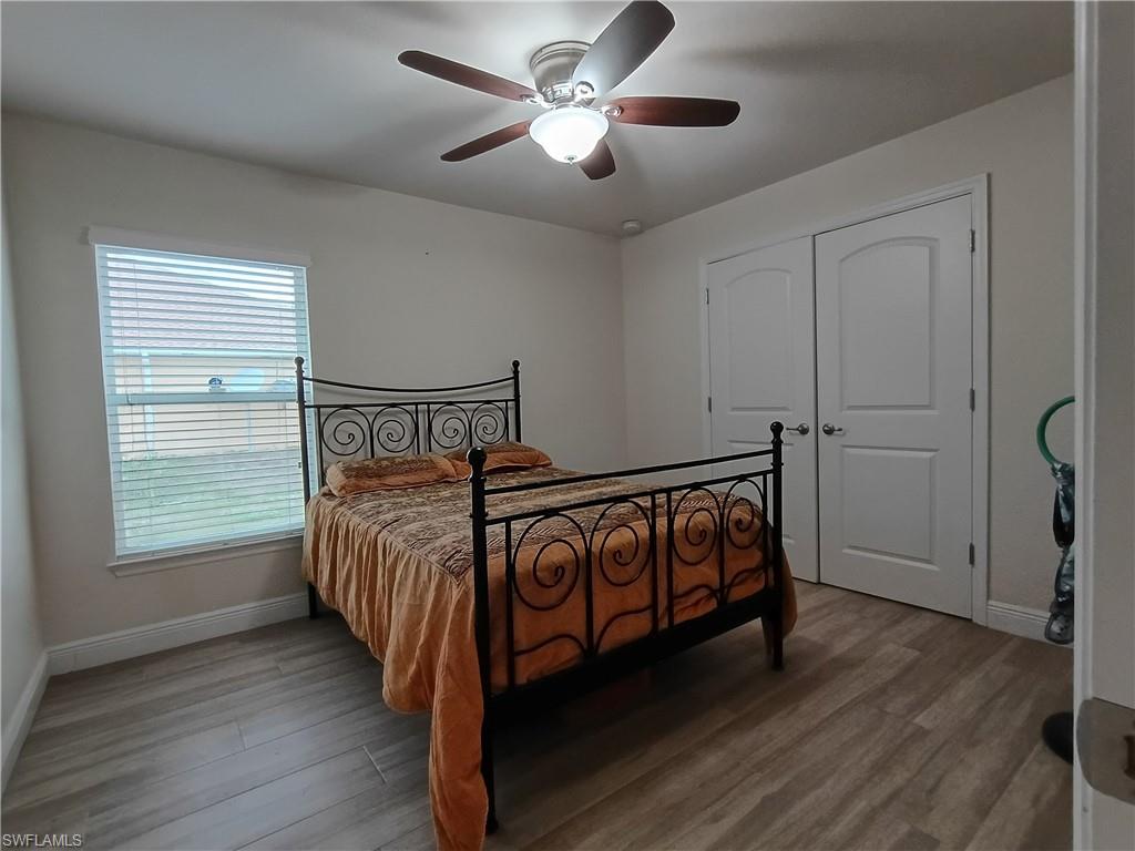 Bedroom featuring wood finished floors, ceiling fan, and a closet