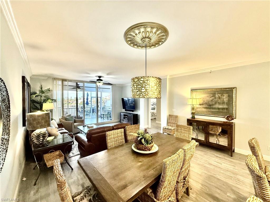 Dining space with ornamental molding, wood finished floors, and ceiling fan