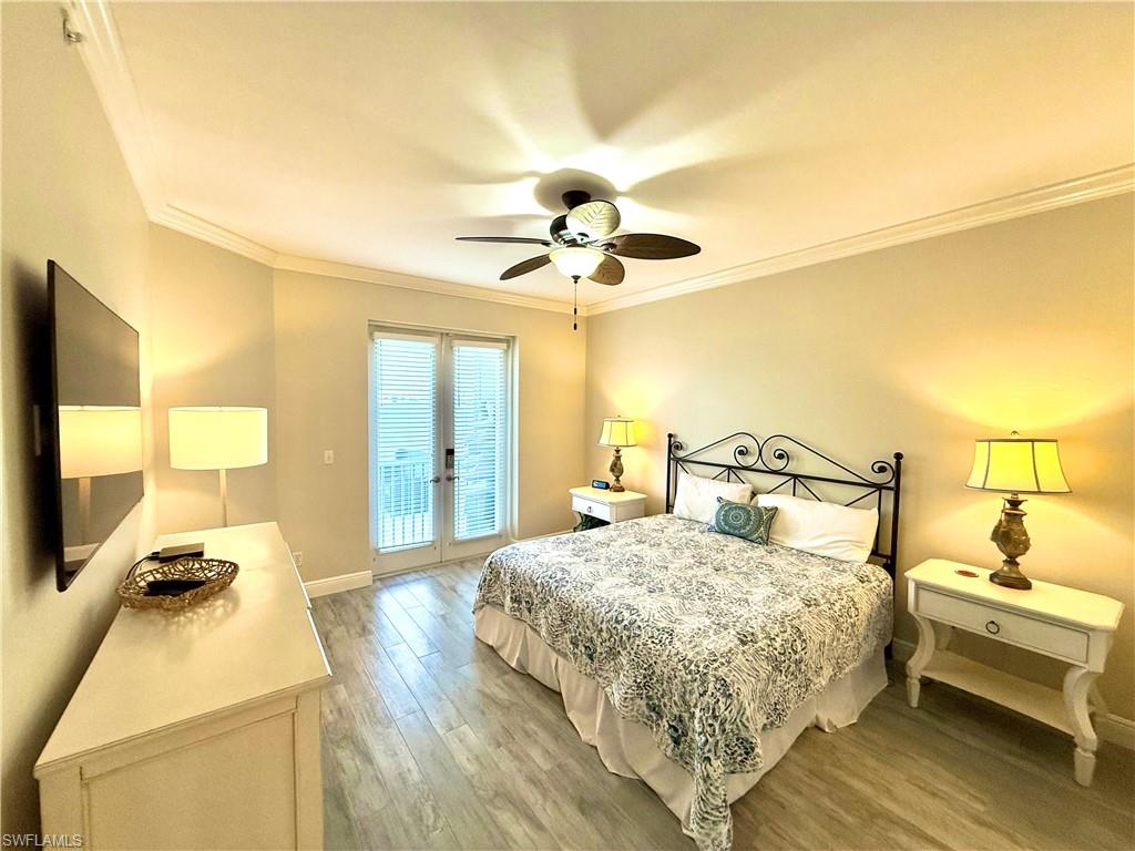 Bedroom with ornamental molding, access to exterior, light wood-style floors, a ceiling fan, and french doors