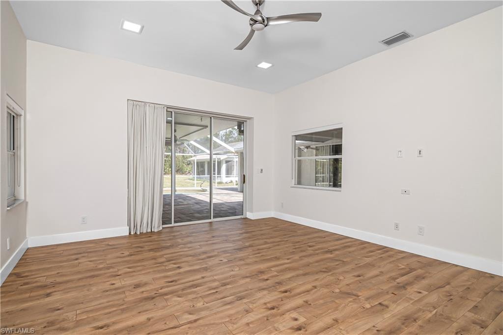Empty room featuring ceiling fan, light wood-type flooring, and a sunroom