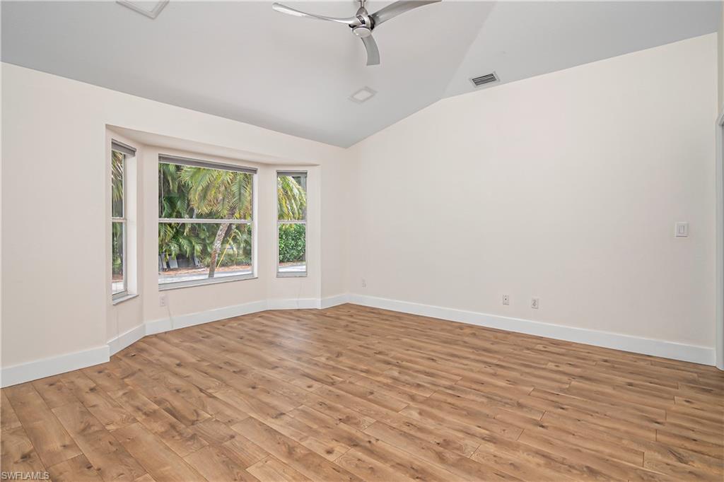 Spare room featuring a ceiling fan, light wood finished floors, and vaulted ceiling