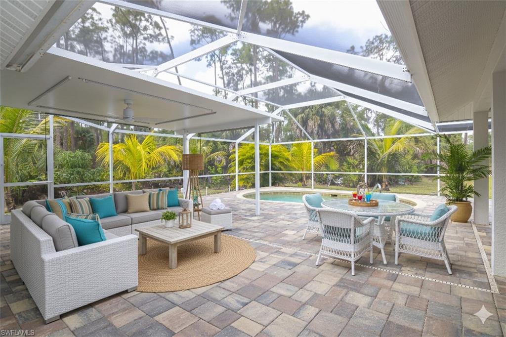 View of patio featuring a sunroom, a lanai, an outdoor pool, outdoor dining space, and an outdoor hangout area
