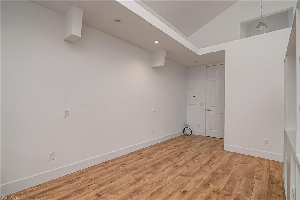 Spare room featuring light wood-style flooring, recessed lighting, and high vaulted ceiling