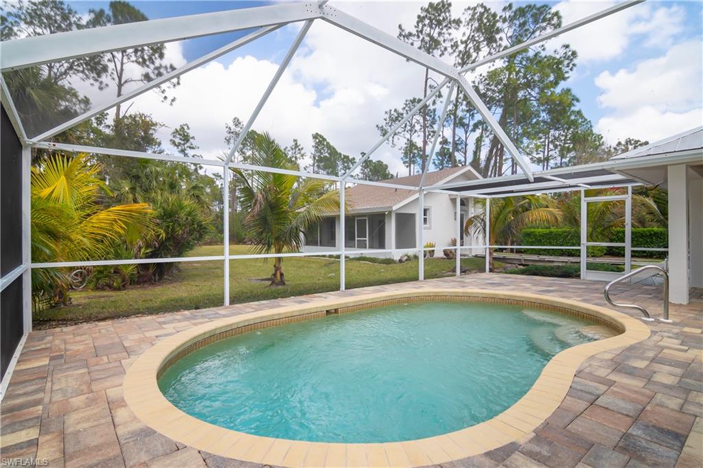 Swimming pool with a sunroom, a patio, and a lanai