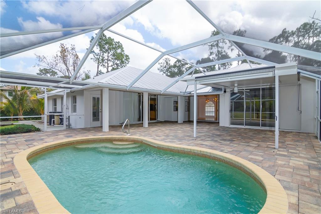Rear view of house featuring a sunroom, a patio, an outdoor pool, and a lanai