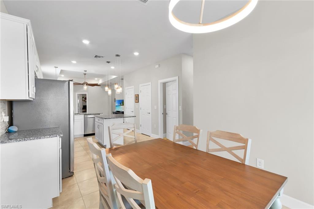 Dining area featuring recessed lighting, light tile patterned floors, and a chandelier