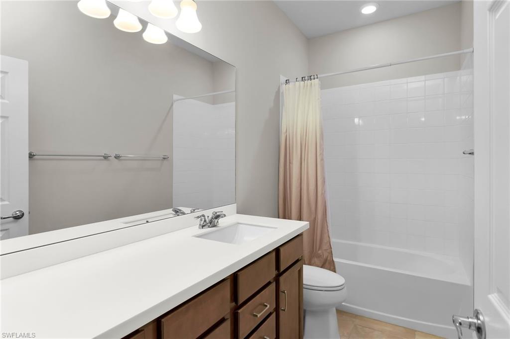 Bathroom with shower / bath combination with curtain and vanity