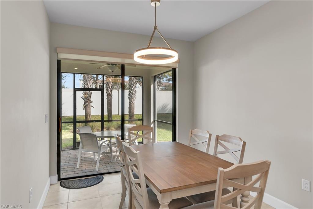 Dining space with light tile patterned flooring and baseboards